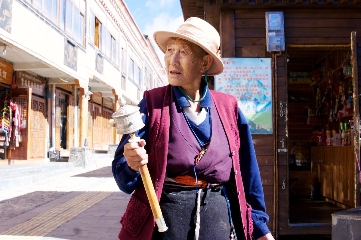 Pilgerin in Litang mit Gebetsmühle